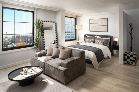 a living room with a couch and a bed in a bedroom